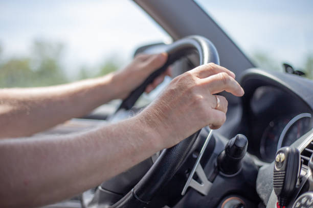 istock a man drives a car, hands lie on the steering wheel, car interior from the inside 1257790878