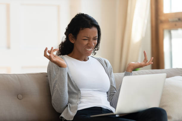 istock Annoyed young black girl looking at laptop screen 1257791003