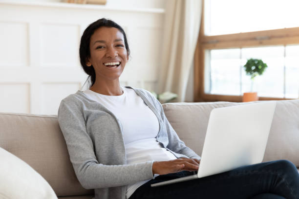 istock African american girl using laptop and sit on sofa 1257791087