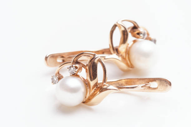 istock Pair of earrings with pearls on light surface 1257795953