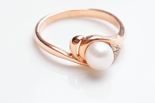 Golden ring with pearl shot with reflection close-up