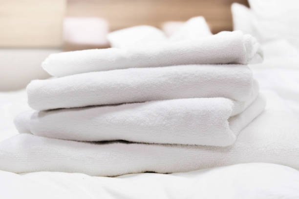 istock Stacked white spa towels on bed in hotel room 1257797882