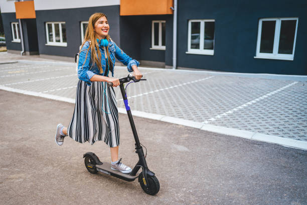 istock Woman riding electric kick scooter 1257797904