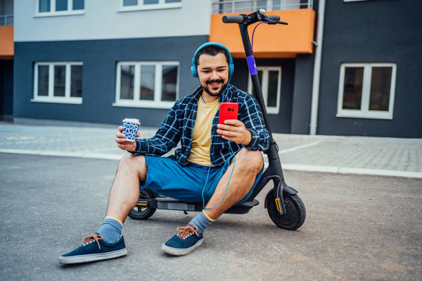 istock Man sitting on electric scooter and using phone 1257798926