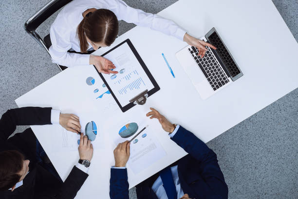 istock Group of business people analyzing financial documents, view from above. Business team at meeting 1257800199