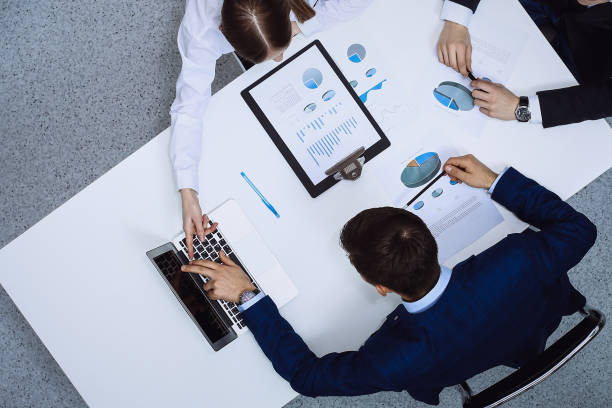 istock Group of business people analyzing financial documents, view from above. Business team at meeting 1257800214