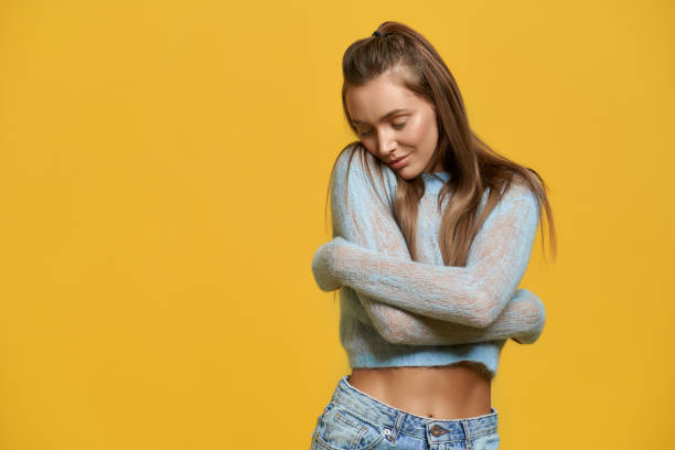 istock Charming young lady hugging herself and smiling 1257801394