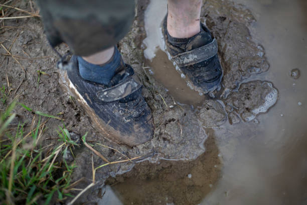 istock The child's feet are covered in mud. 1257801825