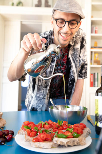 istock Happy Man Cooking - Preparing Bruschetta Bread 1257805477