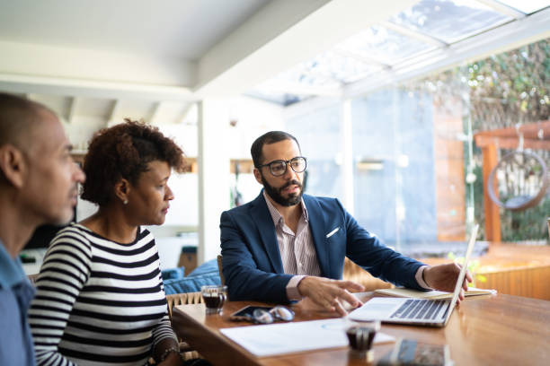 Couple talking to finance advisor at home Couple talking to finance advisor at home professional advice stock pictures, royalty-free photos & images