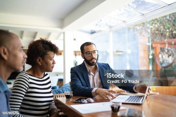 Couple Talking To Finance Advisor At Home Stock Photo - Download Image Now - Financial Advisor, Customer, Advice