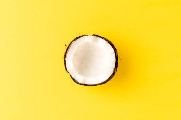 istock Half of fresh coconut on yellow background. Top view 1257805743