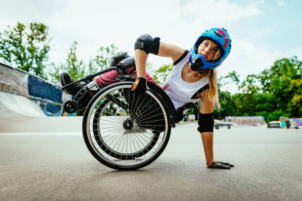 Disabled woman in wheelchair doing stunts in skate park after lockdown Generation Z woman in wheelchair practicing stunts in skate park. Determination, courage and confidence shown in this extreme sport done by disabled woman. athlete with disabilities photos stock pictures, royalty-free photos & images