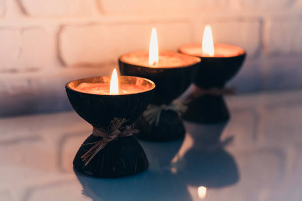 istock Burning spa aroma candles in coconut shell on a glass white table, cozy home interior 1257808210
