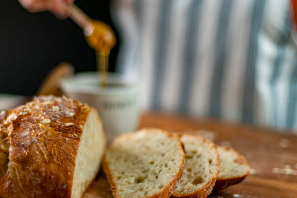istock Honey Oat Loaf on Wood Cuting Board with Honey 1257808496