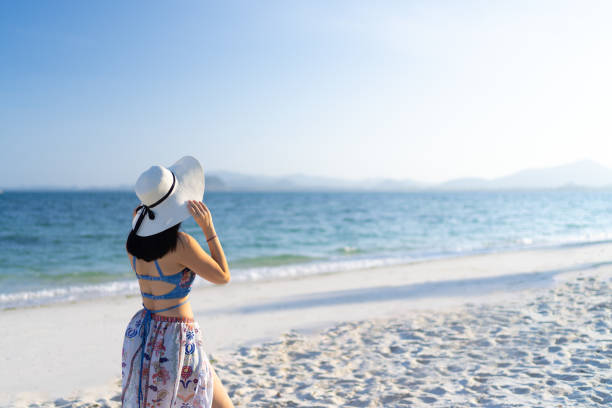 istock Happy women wearing beach sun hat on the beach 1257808593