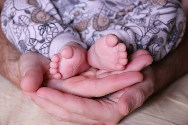 istock Father with newborn baby son legs 1257808685