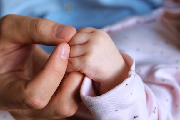 istock Father's male hand holding a child's small hand 1257813385
