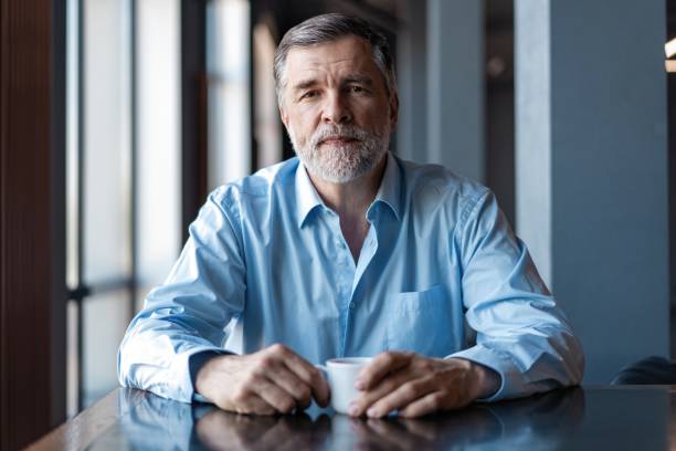 istock Pensive businessman drinking coffee in cafe and looking away. 1257813682