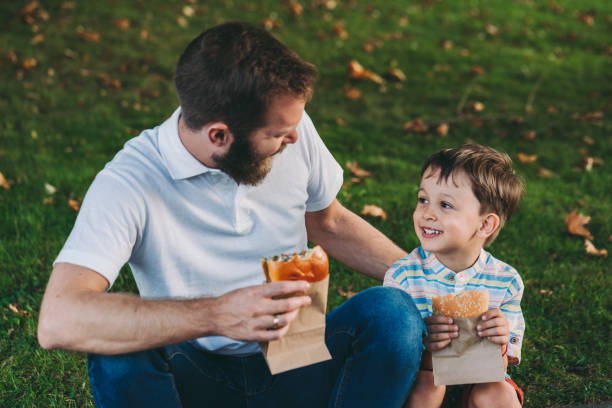 istock Single father and kid enjoying to eat fast food 1257813916