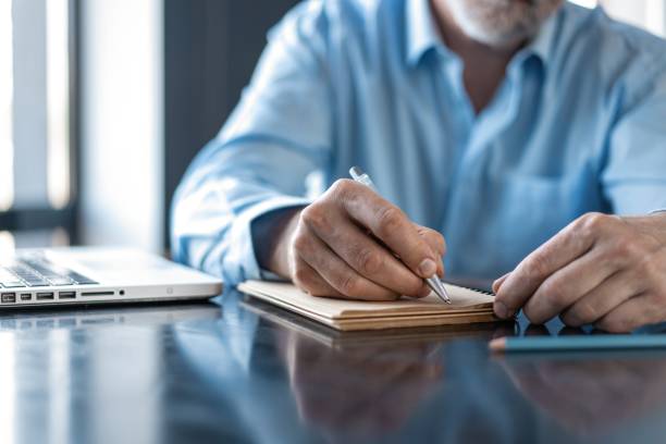 istock Businessman sitting in a business center restaurant, looking through documents. 1257814501