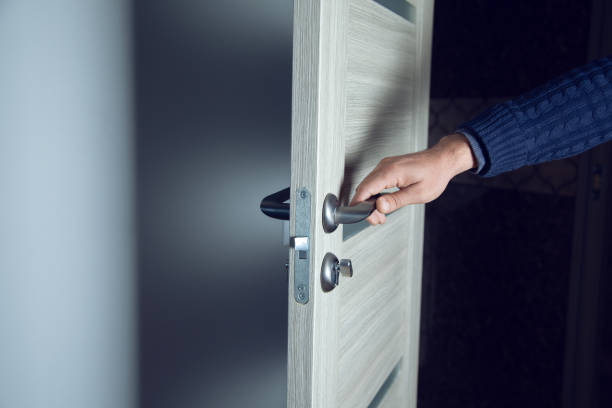 istock man hand in wooden door 1257814845