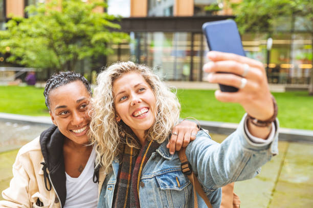 istock Happy mixed race girlfriends taking a selfie and kissing 1257815651