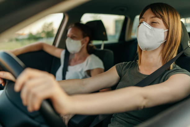 istock Driving a car with protective masks 1257817570