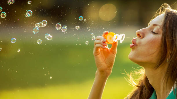 istock Beautiful girl blowing soap bubbles 1257821555