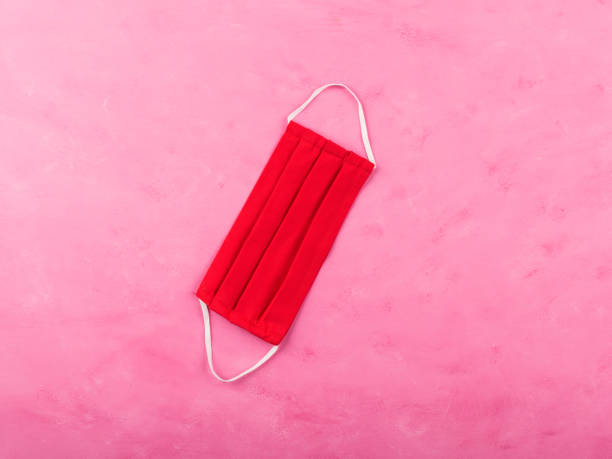 istock Red face mask on pink background. Coronavirus 1257822673