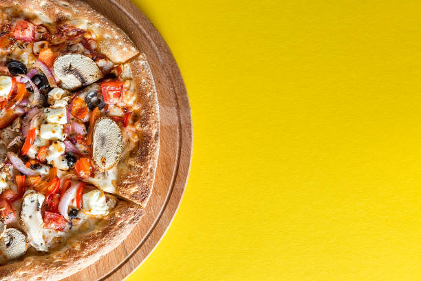 istock Pizza with vegetables on a bright yellow background. 1257823069