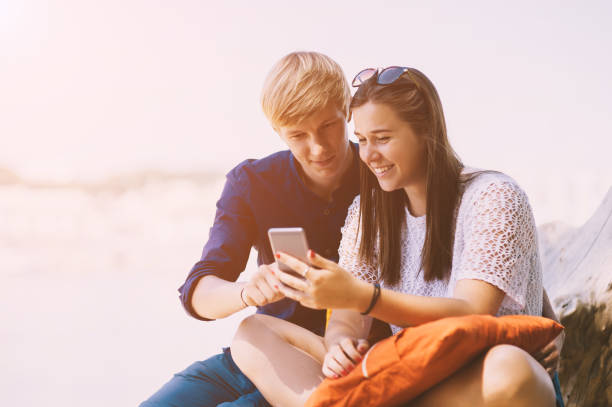 istock Young couple uses a smartphone on the beach in summer 1257824176