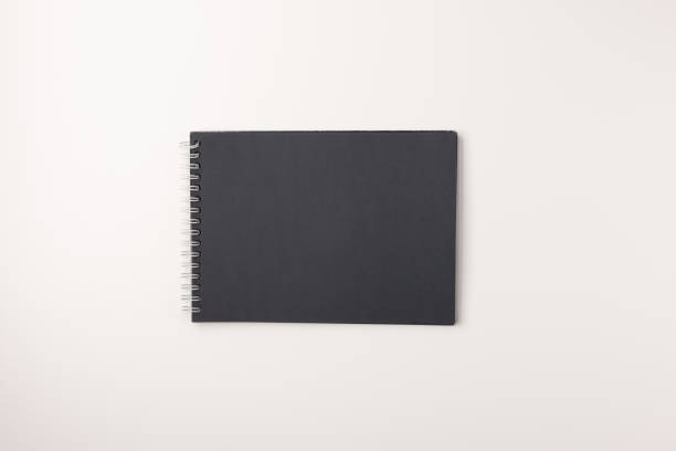 istock Black sketchbook isolated on white background, top view. 1257827689