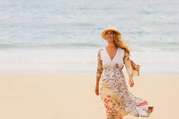 istock Woman walking at the beach and smiling 1257827838