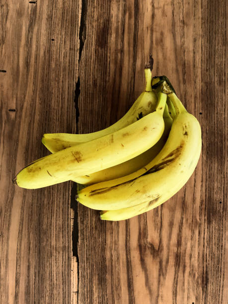 istock Bunch of bananas on a wooden surface 1257828028