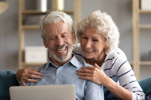 istock Smiling older couple looking at laptop screen together close up 1257831191