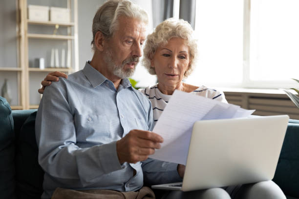 istock Serious older couple managing budget together, reading documents 1257831202