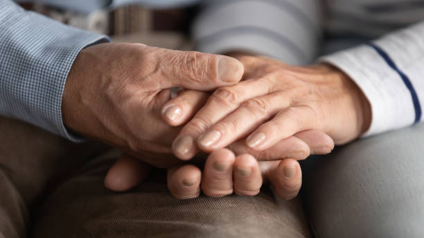 istock Close up mature couple holding hands, support and care 1257831216