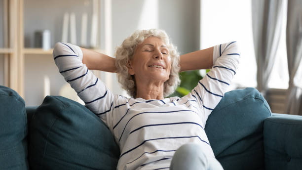 istock Smiling older woman leaning back, relaxing on cozy couch 1257831223