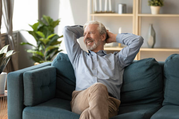 istock Smiling mature man dreaming, relaxing on cozy couch 1257831225