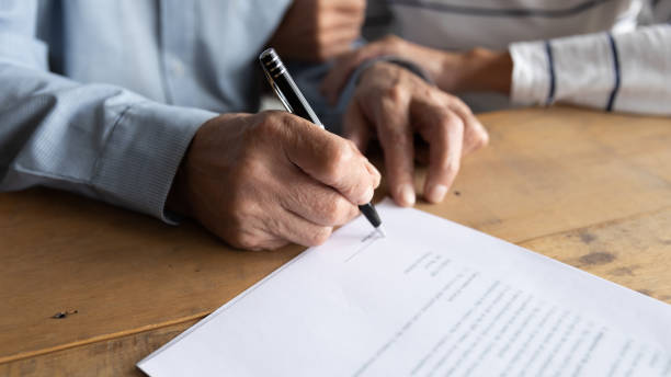 istock Close up older man putting signature on legal documents 1257831279