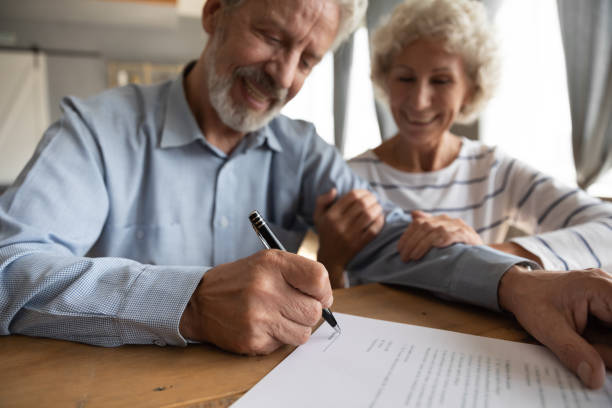 istock Close up satisfied older couple signing documents, making deal 1257831280
