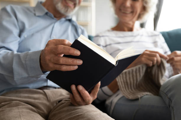 istock Happy older husband reading book while wife knitting 1257831293