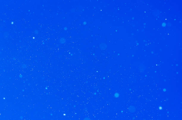 istock Falling snow over blue background in free space 1257832107