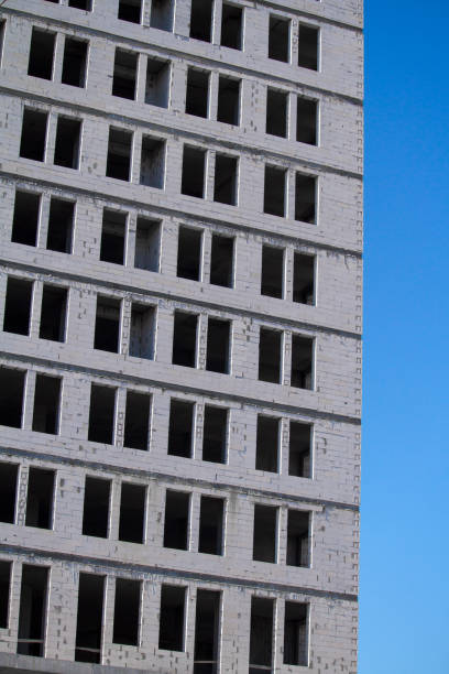 istock New multi-storey ready for commissioning white brick building against blue sky, free space for text 1257834320