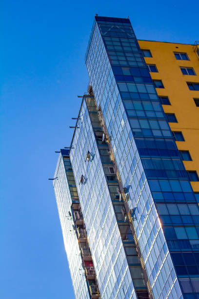 nuovo blocco di appartamenti moderni con balconi e sfondo cielo blu, spazio libero per il testo - high rise apartments foto e immagini stock
