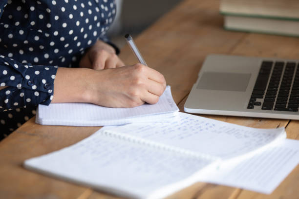istock Focused millennial woman noting important information, sitting at table. 1257836743
