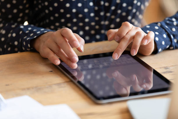 istock Close up indian woman typing message on tablet. 1257836751