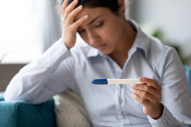 Focus on pregnancy test in hands of frustrated indian woman. Focus on pregnancy test in hands of frustrated stressed young indian woman. Unhappy depressed millennial hindu girl dissatisfied with result, unwanted pregnancy, fertility problem, bad news concept. unwanted pregnancy stock pictures, royalty-free photos & images