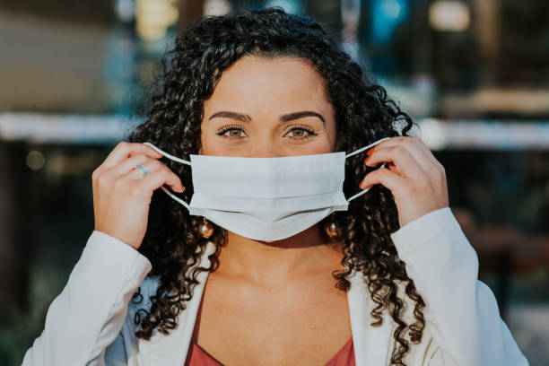 istock Smiling woman behind face protection mask 1257836906